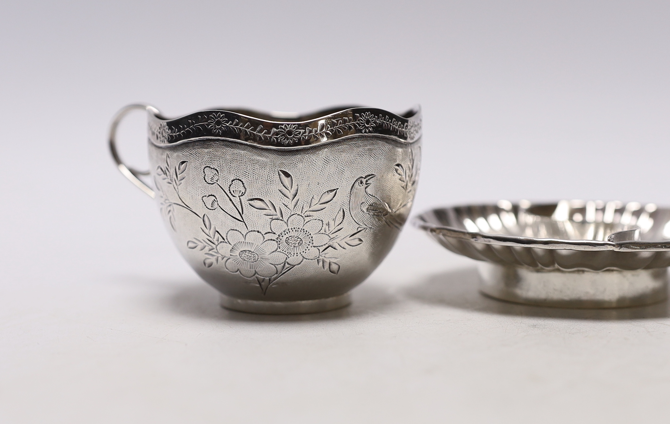 Chinese white metal items including two shaped dishes, a tea cup and two dragon dishes, largest 10.2cm, 8.2oz.